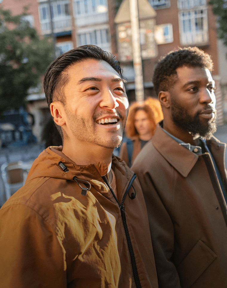 Smiling friends walk down a street in a new country.